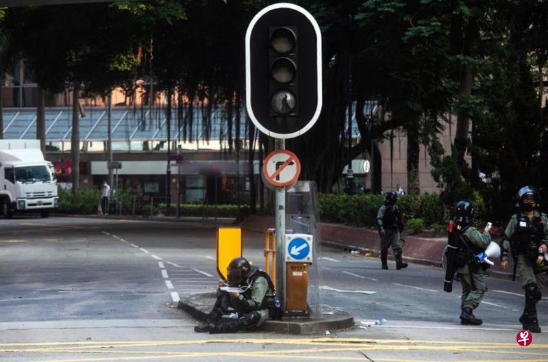 香港社会抗争期间,一名防暴警员因职务在身,靠在遭破坏的交通灯下席地吃饭盒。(取自香港警务处面簿) 香港社会抗争期间,一名防暴警员因职务在身,靠在遭破坏的交通灯下席地吃饭盒。(取自香港警务处面簿)