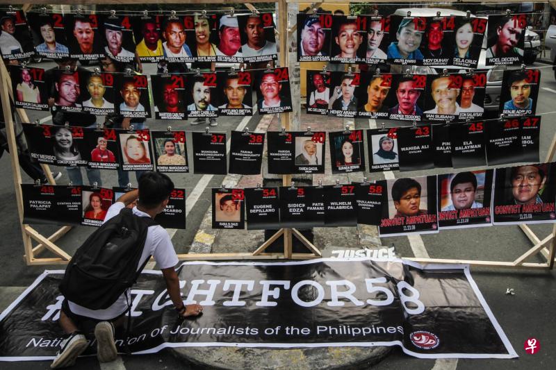 11月23日是这起菲律宾最血腥政治暴力事件的10周年纪念,一名男子在马尼拉的总统府外竖起58名死难者的照片,希望法律早点为他们讨回公道。(法新社) 11月23日是这起菲律宾最血腥政治暴力事件的10周年纪念,一名男子在马尼拉的总统府外竖起58名死难者的照片,希望法律早点为他们讨回公道。(法新社)