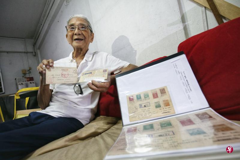 95岁的陈兆永决定把有约70年历史的二战邮集全部捐给博物馆,包括他手上的两张英军俘虏明信片,以及文件夹内日本为纪念攻陷新加坡一周年而推出的邮票首日封。(何家俊摄) 95岁的陈兆永决定把有约70年历史的二战邮集全部捐给博物馆,包括他手上的两张英军俘虏明信片,以及文件夹内日本为纪念攻陷新加坡一周年而推出的邮票首日封。(何家俊摄)