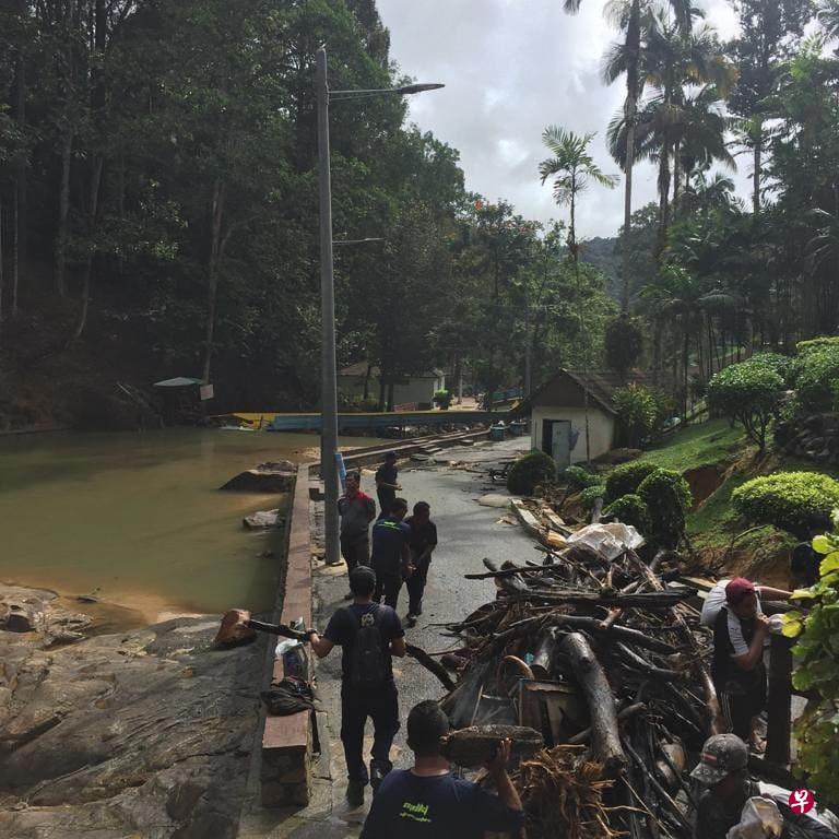 工作人员忙着清理随洪水冲下来的树枝和杂物。(星洲日报) 工作人员忙着清理随洪水冲下来的树枝和杂物。(星洲日报)