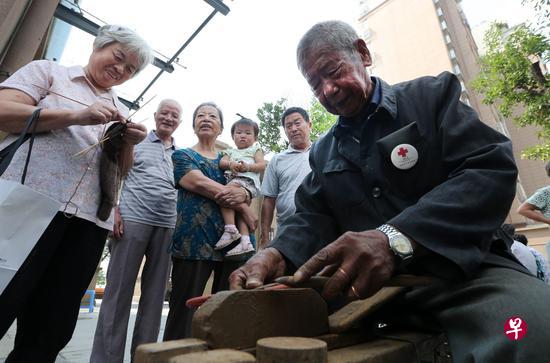 吴锦泉为社区居民们磨刀(新华社) 吴锦泉为社区居民们磨刀(新华社)