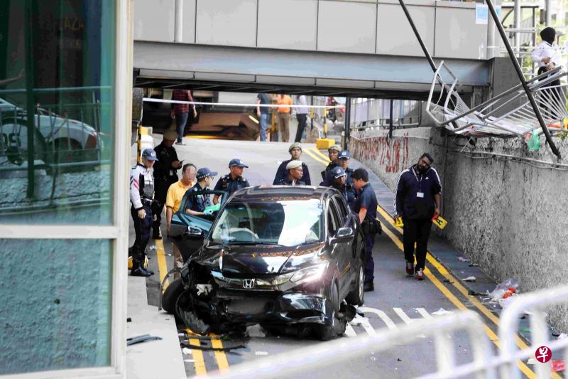 幸运商业中心公寓外今午发生恐怖致命车祸,一辆黑色休旅车不知何故失控撞上公寓停靠处的铁杆,再撞入人群中,导致两人死亡。(陈斌勤摄) 幸运商业中心公寓外今午发生恐怖致命车祸,一辆黑色休旅车不知何故失控撞上公寓停靠处的铁杆,再撞入人群中,导致两人死亡。(陈斌勤摄)