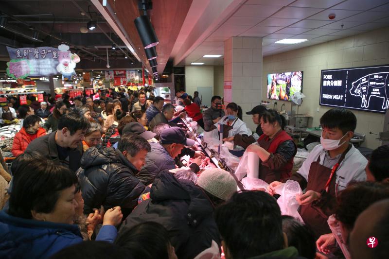 中国农业农村部：猪肉批发市场均价降逾18%。图为山东滨州顾客在新开张的一家超市内抢购猪肉。（法新社）