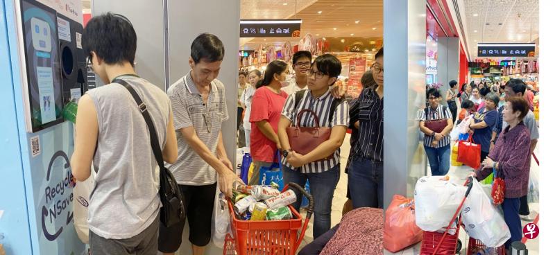 左图:公众只需将空瓶罐投入机器,每四个容器即可兑换两角钱的平价超市折价券。右图:宏茂桥的反向贩卖机今早也出现长长的人龙。 左图:公众只需将空瓶罐投入机器,每四个容器即可兑换两角钱的平价超市折价券。右图:宏茂桥的反向贩卖机今早也出现长长的人龙。