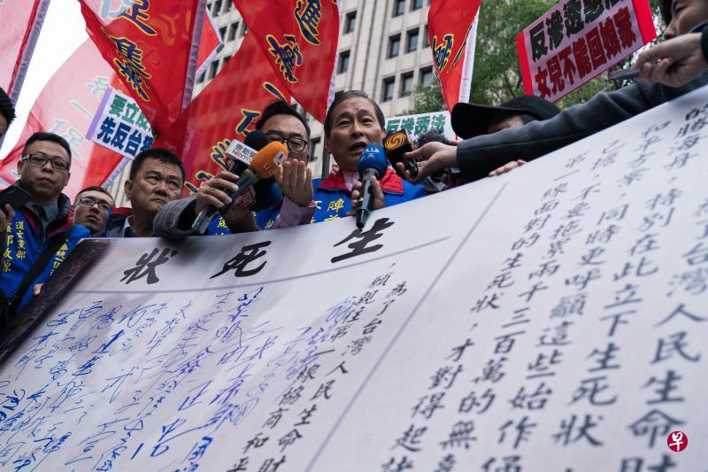 台湾立法院昨天审查备受争议的《反渗透法》时,上百名统派人士在场外集结抗议,包括被指为该法适用对象的中华统一促进党总裁张安乐(中)。为表达不满,张安乐率领统派人士签署自备的“生死状”,表达到中国大陆与北京协商两岸和平方案的意愿。(黄顺杰摄) 台湾立法院昨天审查备受争议的《反渗透法》时,上百名统派人士在场外集结抗议,包括被指为该法适用对象的中华统一促进党总裁张安乐(中)。为表达不满,张安乐率领统派人士签署自备的“生死状”,表达到中国大陆与北京协商两岸和平方案的意愿。(黄顺杰摄)