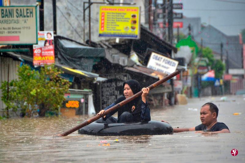 在雅加达附近的城市勿加泗(Bekasi),未退去的水位及胸,民众出行时必须划着充气内胎在水中穿行。(法新社) 在雅加达附近的城市勿加泗(Bekasi),未退去的水位及胸,民众出行时必须划着充气内胎在水中穿行。(法新社)