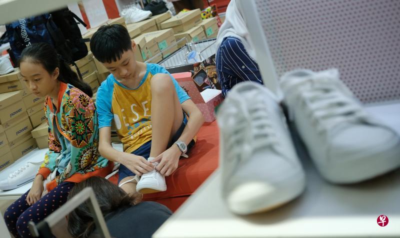 昨天元旦日,各购物商场有不少家长和学生趁开学前夕添购校服和鞋子等用品。图为在怡丰城一鞋店试穿校鞋的学生。(林泽锐摄) 昨天元旦日,各购物商场有不少家长和学生趁开学前夕添购校服和鞋子等用品。图为在怡丰城一鞋店试穿校鞋的学生。(林泽锐摄)