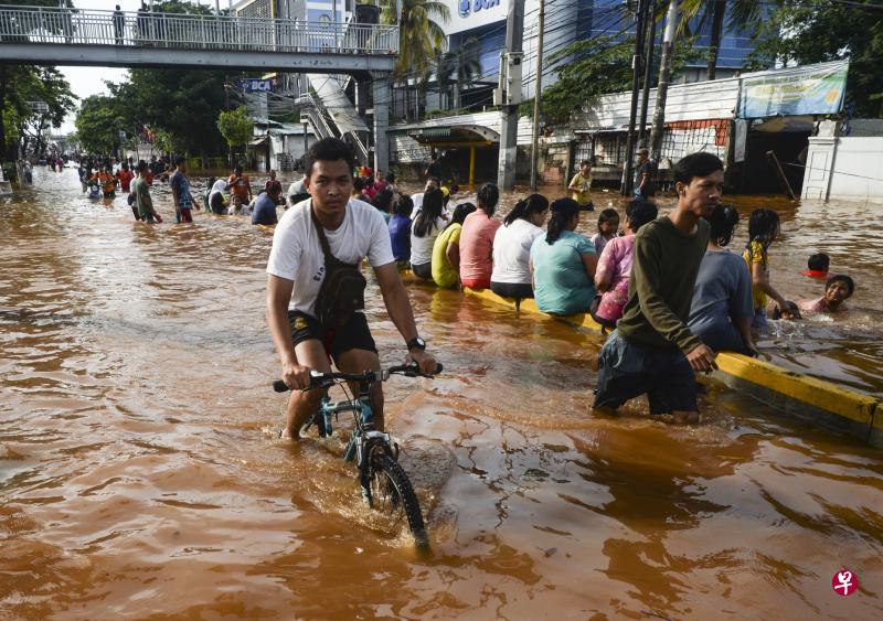 在雅加达的城镇地区,水位在1月2日仍未退去,不少零售商受洪灾影响已停业多日,经济活动似乎停摆,民众只能在淹水的街上嬉水聊天。(新华社) 在雅加达的城镇地区,水位在1月2日仍未退去,不少零售商受洪灾影响已停业多日,经济活动似乎停摆,民众只能在淹水的街上嬉水聊天。(新华社)