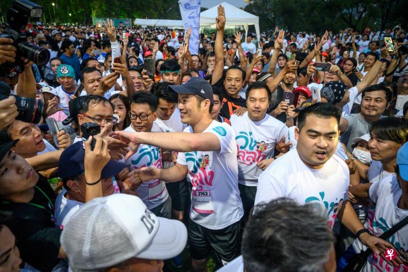 泰国未来前进党党魁塔纳通(中)参加“反独裁统治”竞跑时与支持者握手。(法新社) 泰国未来前进党党魁塔纳通(中)参加“反独裁统治”竞跑时与支持者握手。(法新社)