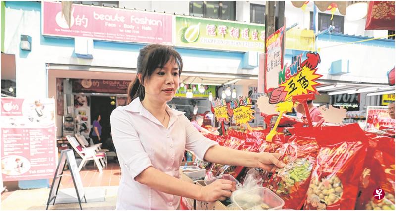 高志英特地在自己的美容院前租下一个摊位卖新年糖果和瓜子。(唐家鸿摄) 高志英特地在自己的美容院前租下一个摊位卖新年糖果和瓜子。(唐家鸿摄)