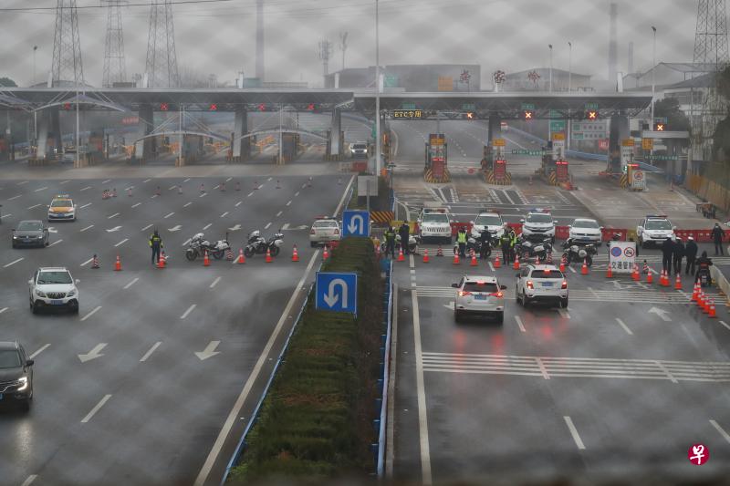 湖北省交通运输厅昨天封闭武汉周边的多处高速公路口,图为警方在武汉市洪山区武鄂高速公路的龚家岭收费站进行交通管制。(中新社) 湖北省交通运输厅昨天封闭武汉周边的多处高速公路口,图为警方在武汉市洪山区武鄂高速公路的龚家岭收费站进行交通管制。(中新社)