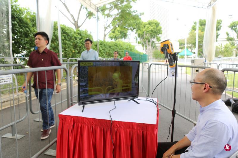 人民协会将在妆艺大游行演出范围的所有入口处装置体温检测器,体温过高者不能入场。图为工作人员昨天在F1维修大楼外测试设置好的体温检测器。(饶凯源摄) 人民协会将在妆艺大游行演出范围的所有入口处装置体温检测器,体温过高者不能入场。图为工作人员昨天在F1维修大楼外测试设置好的体温检测器。(饶凯源摄)