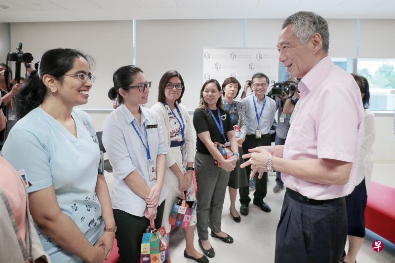 李显龙总理(右)昨天走访国家传染病中心,为前线医疗人员打气。他受访时指出,政府正密切留意武汉肺炎疫情的发展,并会在必要时调整措施。(海峡时报) 李显龙总理(右)昨天走访国家传染病中心,为前线医疗人员打气。他受访时指出,政府正密切留意武汉肺炎疫情的发展,并会在必要时调整措施。(海峡时报)