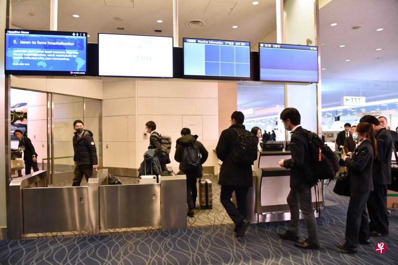 2020年1月28日,日本厚生劳动省的工作人员通过东京羽田国际机场客运大楼的登机口,准备登上一架政府包机前往武汉撤离国民。(法新社) 2020年1月28日,日本厚生劳动省的工作人员通过东京羽田国际机场客运大楼的登机口,准备登上一架政府包机前往武汉撤离国民。(法新社)