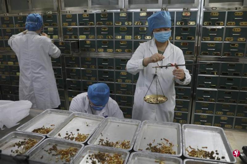 北京地坛医院中医药药师在配置药物。(中新社) 北京地坛医院中医药药师在配置药物。(中新社)