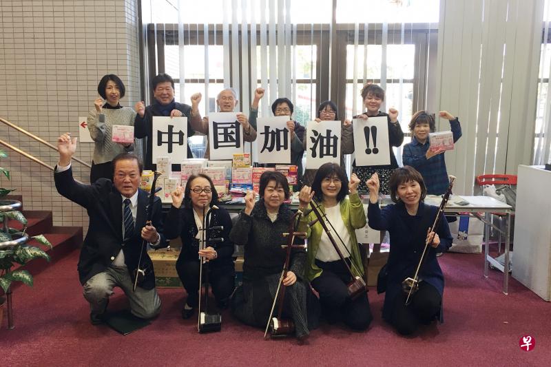 在日本名古屋,张滨二胡学院的日本学员举着“中国加油”的标语和他们向中国捐赠的口罩一起合影。(新华社) 在日本名古屋,张滨二胡学院的日本学员举着“中国加油”的标语和他们向中国捐赠的口罩一起合影。(新华社)