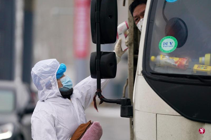 2月21日,在中国哈阿高速哈尔滨出口,卫生防疫人员在给准备进城车辆上的人员测体温。(新华社) 2月21日,在中国哈阿高速哈尔滨出口,卫生防疫人员在给准备进城车辆上的人员测体温。(新华社)