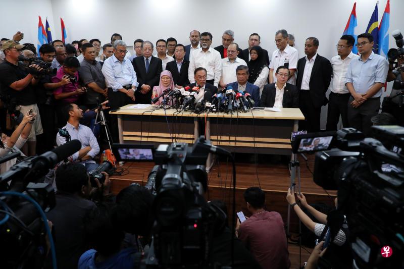 在马来西亚过渡首相马哈迪发表特别全国演说后,公正党主席安华(前排左二)宣布,希盟主席理事会召开紧急会议,议决推举他成为候选首相。希盟领袖称,基于马哈迪向希盟三党党魁表示坚持要成立联合政府,造成三党决定临时转变态度,改为支持安华任相。前排左起为安华妻子旺阿兹莎、诚信党主席莫哈末沙布及民行党秘书长林冠英。(路透社) 在马来西亚过渡首相马哈迪发表特别全国演说后,公正党主席安华(前排左二)宣布,希盟主席理事会召开紧急会议,议决推举他成为候选首相。希盟领袖称,基于马哈迪向希盟三党党魁表示坚持要成立联合政府,造成三党决定临时转变态度,改为支持安华任相。前排左起为安华妻子旺阿兹莎、诚信党主席莫哈末沙布及民行党秘书长林冠英。(路透社)