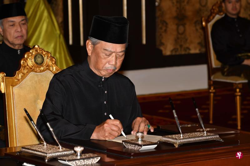 马来西亚第八任首相慕尤丁今早在国家皇宫宣誓后签署文件。（法新社，马来西亚通讯部提供） 