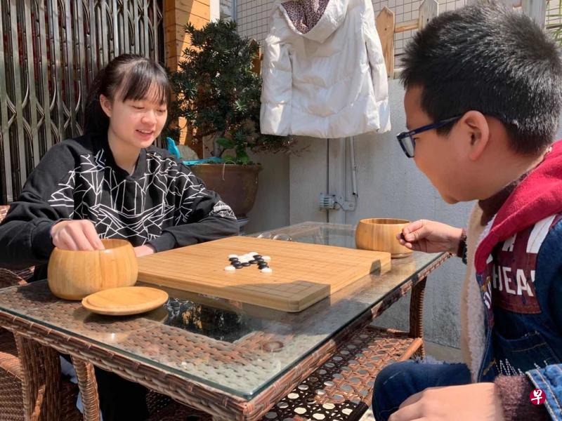 隔离期间,王胤铭(左)在家里与朋友的家人下棋。(受访者提供) 隔离期间,王胤铭(左)在家里与朋友的家人下棋。(受访者提供)