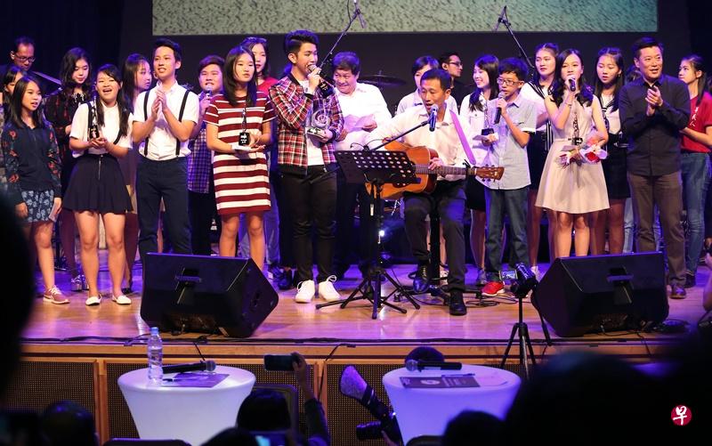 “新空下”全国学生新谣歌唱及创作比赛大决赛,时任教育部 代部长(高等教育及技能)的王乙康(坐者)是受邀嘉宾,他 在活动上一边弹奏吉他,一边和参赛者一起大合唱新谣经典歌 曲《细水长流》。(何家俊摄) “新空下”全国学生新谣歌唱及创作比赛大决赛,时任教育部 代部长(高等教育及技能)的王乙康(坐者)是受邀嘉宾,他 在活动上一边弹奏吉他,一边和参赛者一起大合唱新谣经典歌 曲《细水长流》。(何家俊摄)