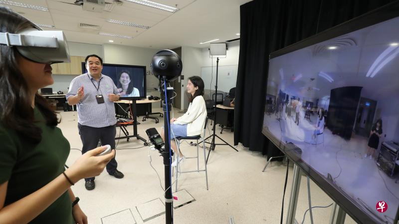 符永忠（中）在实验室示范360°虚拟实境直播教学，学生可选择佩戴VR眼镜，也可直接滑动手机或电脑屏幕上来观看现场360°全景。（陈来福摄）