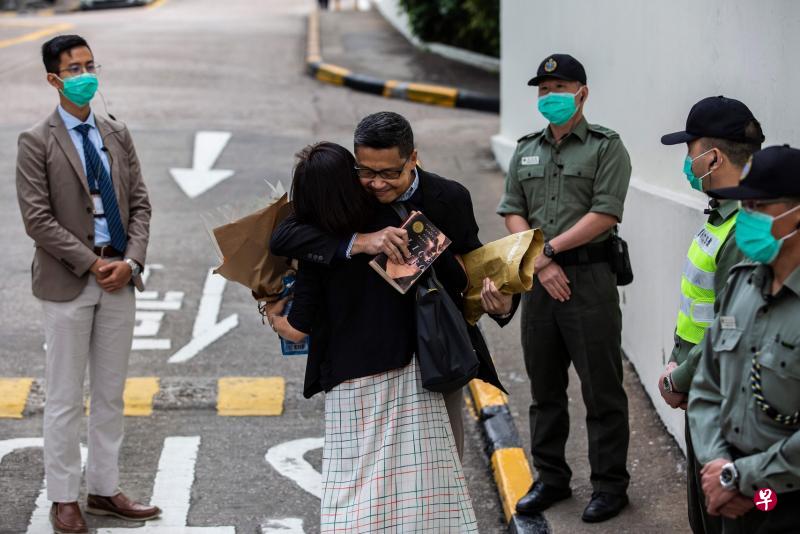香港“占中三子”之一的陈健民(中)昨天出狱后和妻子拥抱。(法新社) 香港“占中三子”之一的陈健民(中)昨天出狱后和妻子拥抱。(法新社)