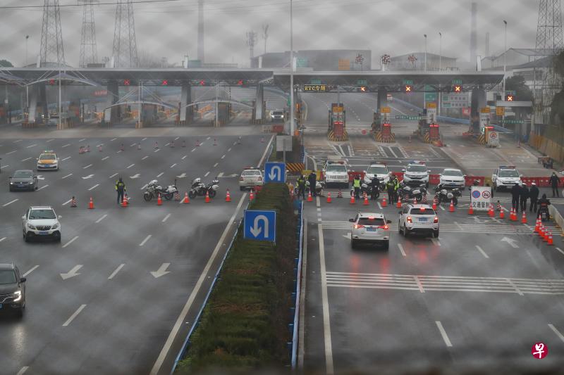 1月23日,湖北省交通运输厅封闭武汉周边的多处高速公路口,图为警方在武汉市洪山区武鄂高速公路的龚家岭收费站进行交通管制。 (中新社) 1月23日,湖北省交通运输厅封闭武汉周边的多处高速公路口,图为警方在武汉市洪山区武鄂高速公路的龚家岭收费站进行交通管制。 (中新社)