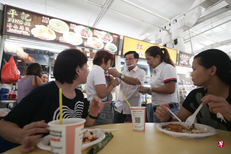 东海岸集选区议员李奕贤(中)派口罩给熟食中心摊贩,鼓励小贩采取最佳作业方式,也提高民众对熟食中心卫生水平的信心。(陈渊庄摄) 东海岸集选区议员李奕贤(中)派口罩给熟食中心摊贩,鼓励小贩采取最佳作业方式,也提高民众对熟食中心卫生水平的信心。(陈渊庄摄)