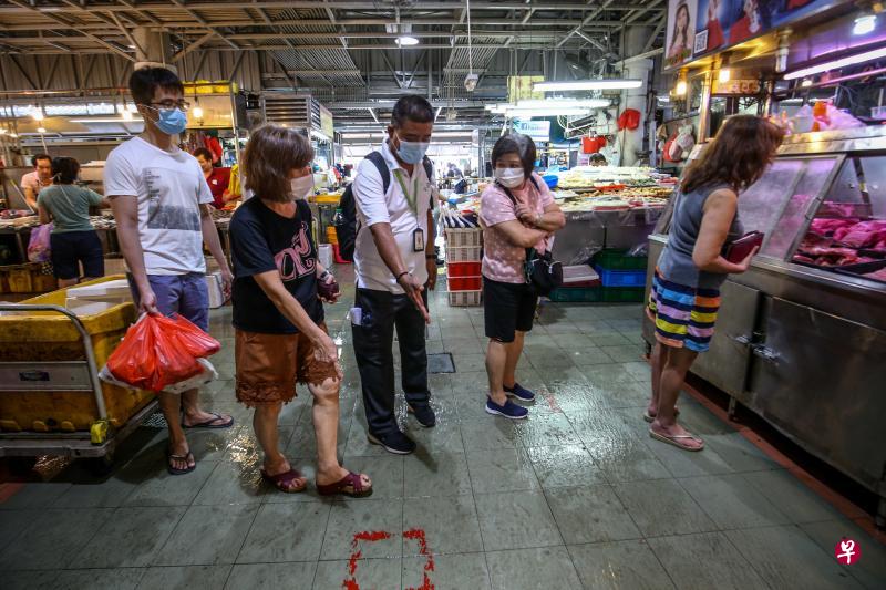 10多名国家环境局执法人员昨早到裕廊西52街第505座的巴刹,提醒公众遵守防疫措施,并向违例公众发出书面劝告。(叶振忠摄) 10多名国家环境局执法人员昨早到裕廊西52街第505座的巴刹,提醒公众遵守防疫措施,并向违例公众发出书面劝告。(叶振忠摄)