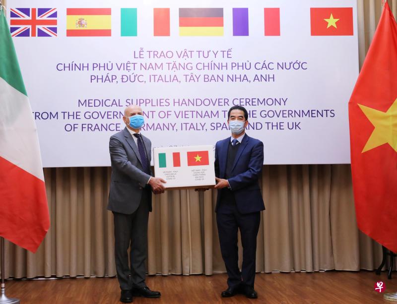 越南向法国、德国、意大利、西班牙和英国捐赠55万个防护口罩,4月7日,越南副外长苏英勇在捐赠仪式上把一盒口罩移交给意大利驻越南大使亚历山德罗。(路透社) 越南向法国、德国、意大利、西班牙和英国捐赠55万个防护口罩,4月7日,越南副外长苏英勇在捐赠仪式上把一盒口罩移交给意大利驻越南大使亚历山德罗。(路透社)
