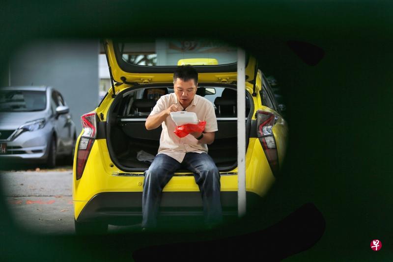德士司机陈俊源下来工作时,若无法回家用餐,只能坐在车上吃饭盒,将不会遭安全距离大使、执法人员或警员阻止。(严宣融摄) 德士司机陈俊源下来工作时,若无法回家用餐,只能坐在车上吃饭盒,将不会遭安全距离大使、执法人员或警员阻止。(严宣融摄)