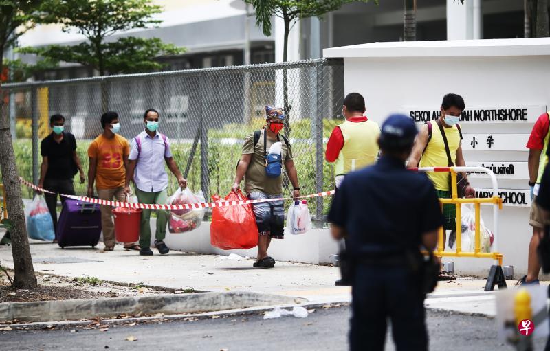 一辆巴士载送10几名客工到北岸小学门口,客工们下车后拖着行李或拿着大包小包进入校舍。(陈渊庄摄) 一辆巴士载送10几名客工到北岸小学门口,客工们下车后拖着行李或拿着大包小包进入校舍。(陈渊庄摄)