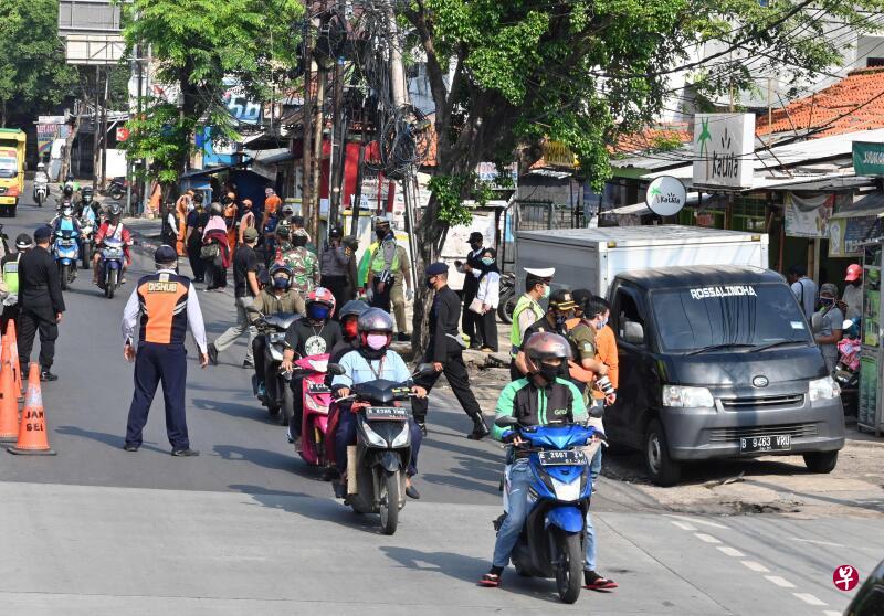4月12日,印尼警方在雅加达设路障检查来往车辆和电单车的载客量,确保民众遵守社交距离措施来防堵冠病疫情。(法新社) 4月12日,印尼警方在雅加达设路障检查来往车辆和电单车的载客量,确保民众遵守社交距离措施来防堵冠病疫情。(法新社)