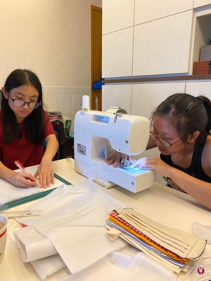 义工吴美玲的孩子分工合作,小女儿陈芳敏(左)负责画布、剪布,大女儿陈芳婷则完成缝纫步骤。(受访者提供) 义工吴美玲的孩子分工合作,小女儿陈芳敏(左)负责画布、剪布,大女儿陈芳婷则完成缝纫步骤。(受访者提供)