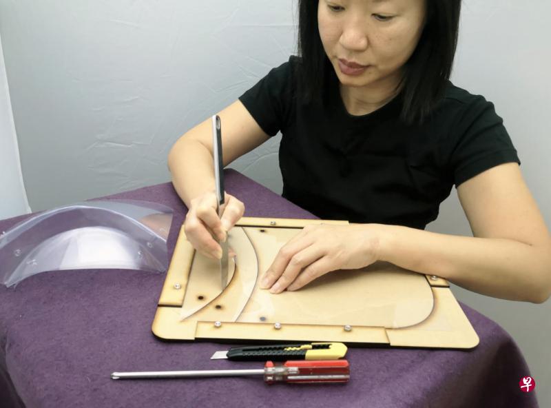 刘韵冰说,只要将透明塑胶片放在模具上,根据指示裁剪和打洞,就能做出简易的防护面罩。(受访者提供) 刘韵冰说,只要将透明塑胶片放在模具上,根据指示裁剪和打洞,就能做出简易的防护面罩。(受访者提供)