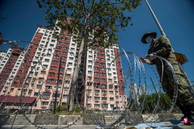 马来西亚为了遏制冠病传播,扩大执行加强行动管制令。图为吉隆坡北部士拉央斯里慕尼花园组屋区,军人在周围道路拉起了铁刺网,禁止人们进出。(星洲日报) 马来西亚为了遏制冠病传播,扩大执行加强行动管制令。图为吉隆坡北部士拉央斯里慕尼花园组屋区,军人在周围道路拉起了铁刺网,禁止人们进出。(星洲日报)