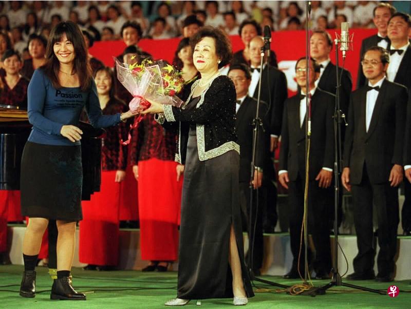 1998年7月25日,第四届中国国际合唱节在北京开幕,新加坡华文报合唱团指挥朱承安(中)及合唱团在演出后向观众致意。(新华社档案照片) 1998年7月25日,第四届中国国际合唱节在北京开幕,新加坡华文报合唱团指挥朱承安(中)及合唱团在演出后向观众致意。(新华社档案照片)
