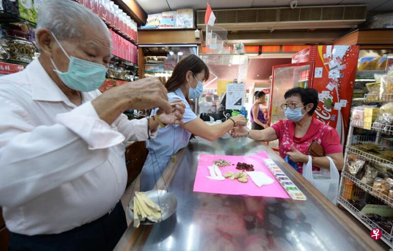 永和兴药行今早恢复售卖产品,但为确保顾客和职员间保持安全距离,店内任何时候最多只能让三名顾客入店,顾客也不能在店内闲逛挑选,拿了产品付了钱就得离开。(潘丰源摄) 永和兴药行今早恢复售卖产品,但为确保顾客和职员间保持安全距离,店内任何时候最多只能让三名顾客入店,顾客也不能在店内闲逛挑选,拿了产品付了钱就得离开。(潘丰源摄)