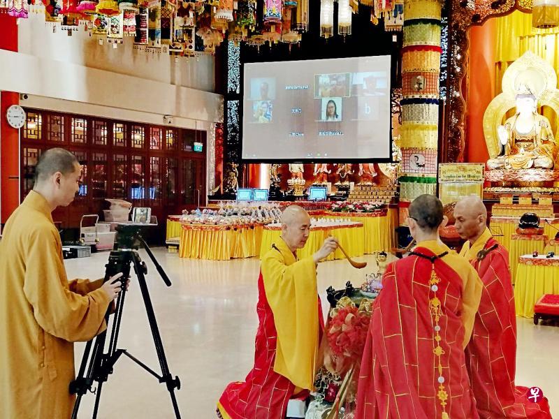 吉祥宝聚寺的正殿昨天成为“直播室”,让待在家中的佛教信徒能在线上参与浴佛法会,庆祝卫塞节。图中的大屏幕显示线上观看节目的信徒和寺院职员。(吉祥宝聚寺提供) 吉祥宝聚寺的正殿昨天成为“直播室”,让待在家中的佛教信徒能在线上参与浴佛法会,庆祝卫塞节。图中的大屏幕显示线上观看节目的信徒和寺院职员。(吉祥宝聚寺提供)