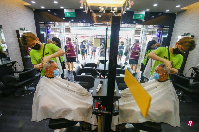本地理发店昨日重新开张，不少国人首次体验戴着口罩剪发。（何家俊摄）