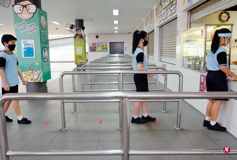 教育部长王乙康强调，学校会做足安全措施，让学生可以安全返校。图为学生在食堂排队买食物时保持安全距离。（取自王乙康面簿）
