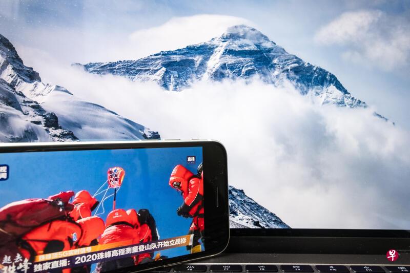 中国2020珠峰高程测量登山队今天上午成功登顶珠穆朗玛峰并开始测量。图为媒体直播珠峰高程测量人员在峰顶竖立觇标。(中新社) 中国2020珠峰高程测量登山队今天上午成功登顶珠穆朗玛峰并开始测量。图为媒体直播珠峰高程测量人员在峰顶竖立觇标。(中新社)