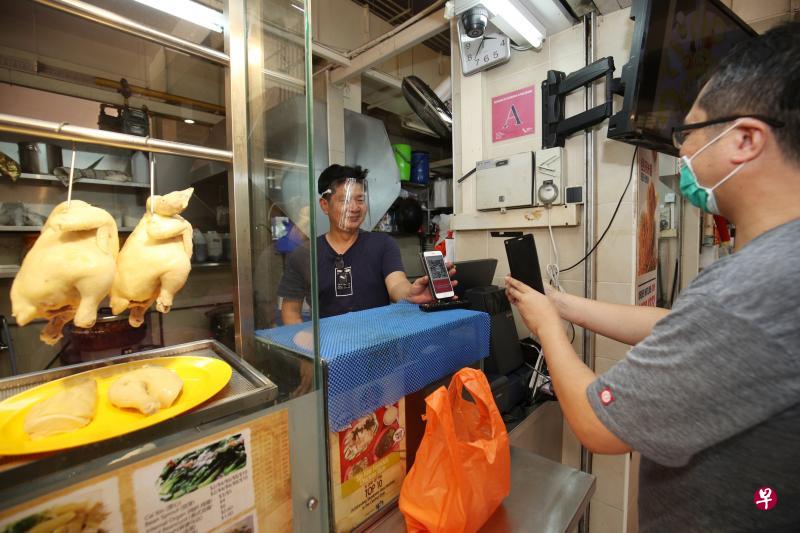洪集丰(左)目前只让熟客使用电子付费,但接下来他将申请全国共用付款QR码的“SGQR”,让所有顾客都有电子付费的选择。(李健玮摄) 洪集丰(左)目前只让熟客使用电子付费,但接下来他将申请全国共用付款QR码的“SGQR”,让所有顾客都有电子付费的选择。(李健玮摄)