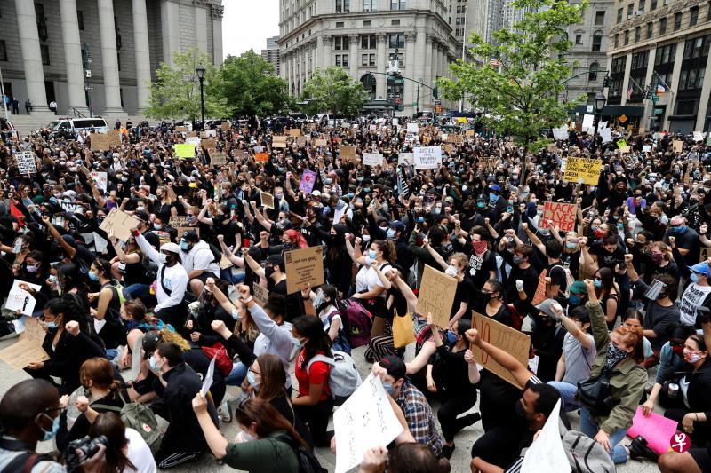 纽约市曼哈顿弗利广场周二涌入大批和平示威者,他们单膝跪地,高举握紧拳头的手,表达对警方暴力执法与美国社会根深蒂固的种族歧视的不满。(路透社) 纽约市曼哈顿弗利广场周二涌入大批和平示威者,他们单膝跪地,高举握紧拳头的手,表达对警方暴力执法与美国社会根深蒂固的种族歧视的不满。(路透社)