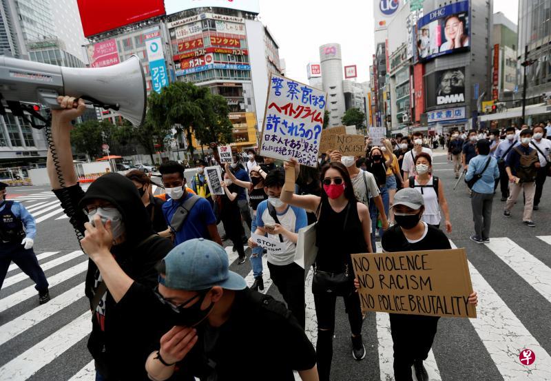 昨天在日本东京，反种族主义示威者举着“没有正义就没有和平”“让我们呼吸”等标语在街头游行。（路透社）