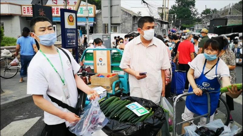 北京东城区一处社区菜市场被关闭，商贩们被迫在路边摆摊，减价销售蔬菜水果和鸡蛋肉类。（孟丹丹摄）