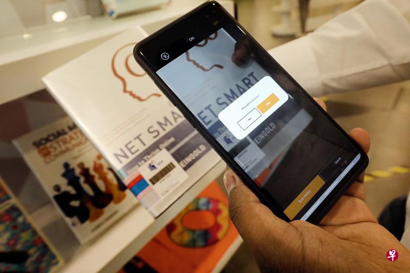 随着所有图书馆昨天起重开,国家图书馆管理局仍鼓励访客使用其手机应用借阅纸本书籍和其他资源,只需用应用扫描书本上的条码,就能轻易完成免触借书程序。(唐家鸿摄) 随着所有图书馆昨天起重开,国家图书馆管理局仍鼓励访客使用其手机应用借阅纸本书籍和其他资源,只需用应用扫描书本上的条码,就能轻易完成免触借书程序。(唐家鸿摄)