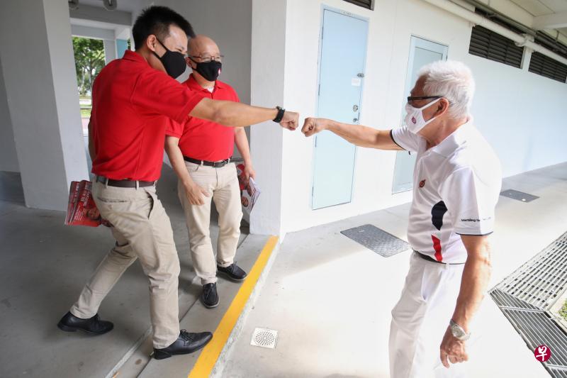 民主党候选人江伟贤(左起)、方月光昨天走访蔡厝港弯组屋时遇见行动党基层人员,疫情中巧遇,双方保持安全距离,江伟贤与对方击拳问候。(李健玮摄) 民主党候选人江伟贤(左起)、方月光昨天走访蔡厝港弯组屋时遇见行动党基层人员,疫情中巧遇,双方保持安全距离,江伟贤与对方击拳问候。(李健玮摄)