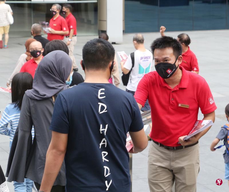 马西岭—油池集选区民主党候选人江伟贤(右)在兀兰民事中心前的广场分派候选人介绍册,向选民拉票。(特约陈福洲摄) 马西岭—油池集选区民主党候选人江伟贤(右)在兀兰民事中心前的广场分派候选人介绍册,向选民拉票。(特约陈福洲摄)